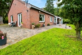 Ansicht vorne - Ruhig wohnen in Ostfriesland: Ebenerdiges Einfamilienhaus mit Scheune und viel Freiraum